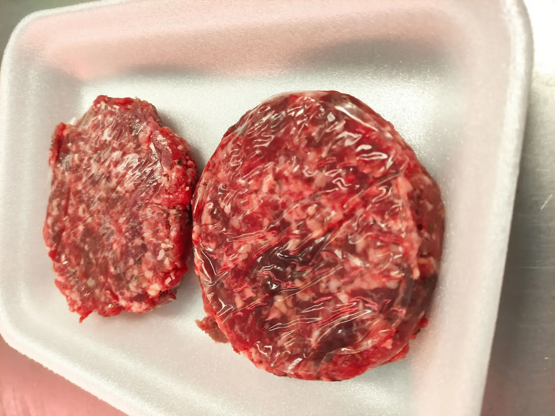 Dos hamburguesas están en una bandeja de poliestireno