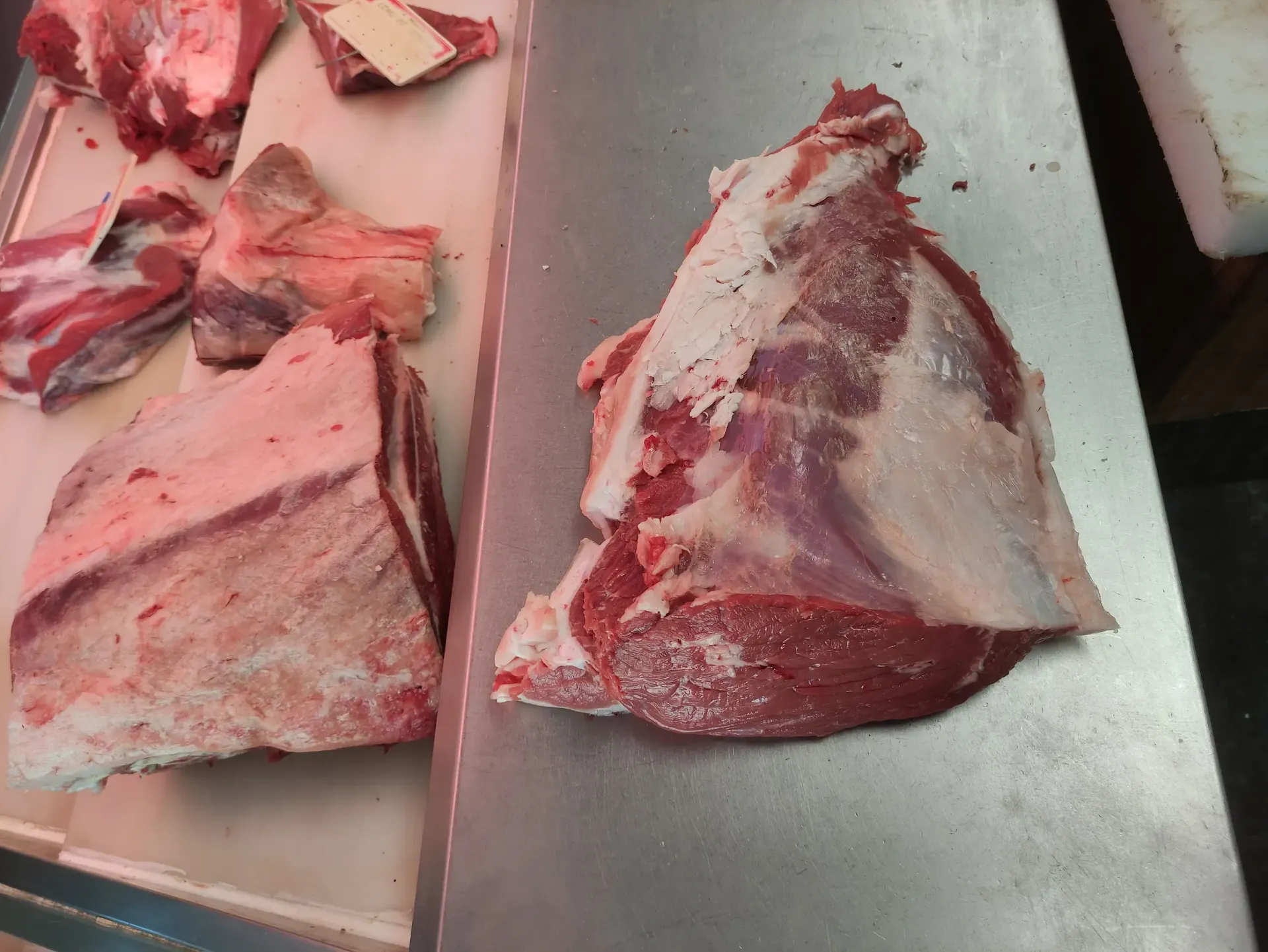 Un trozo de carne cruda está sobre una tabla de cortar.