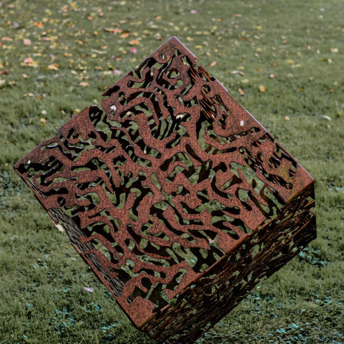 Garten mit Kunstvollem Metallwürfel mit einer Rostpatina und Muster