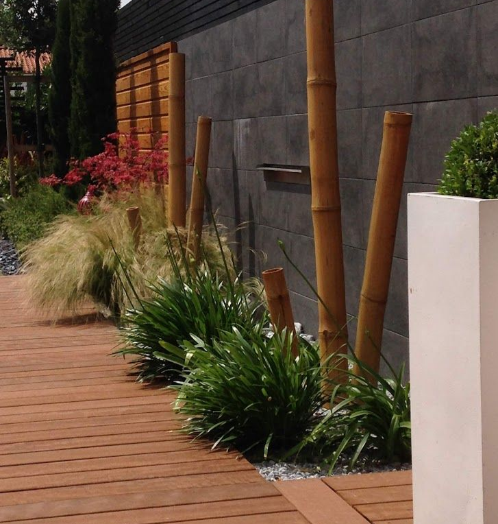 Allée en bois menant à une terrasse avec des chaises jaunes, des marches et de la verdure dans un jardin.