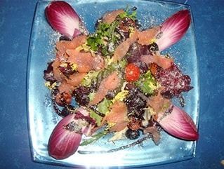 Un primer plano de una ensalada en un plato sobre una mesa.