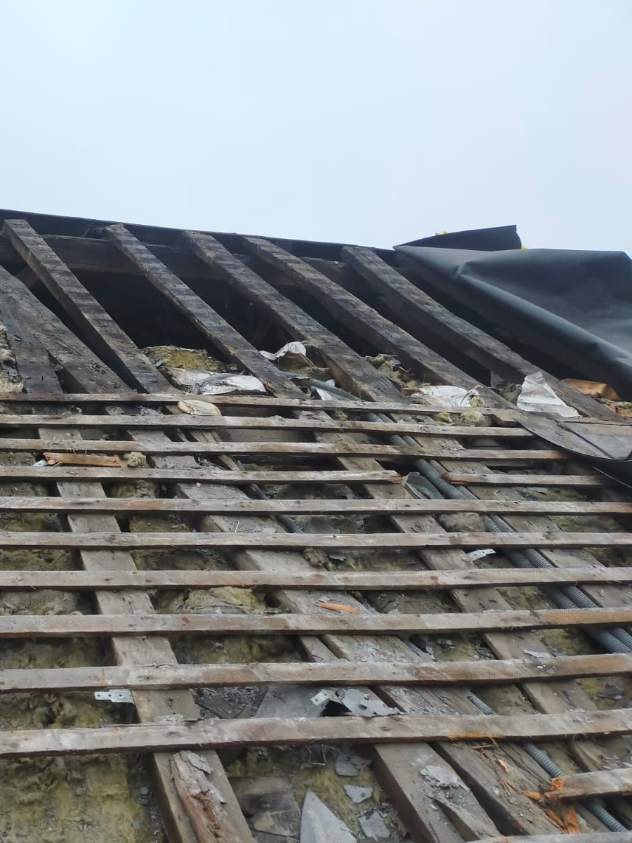 Fermes de toit en bois contre un ciel bleu partiellement nuageux.