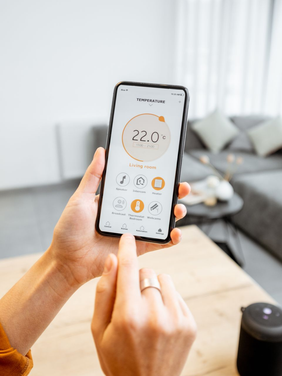 Personne utilisant une application pour smartphone pour contrôler le thermostat, la température affichée est de 22 degrés.