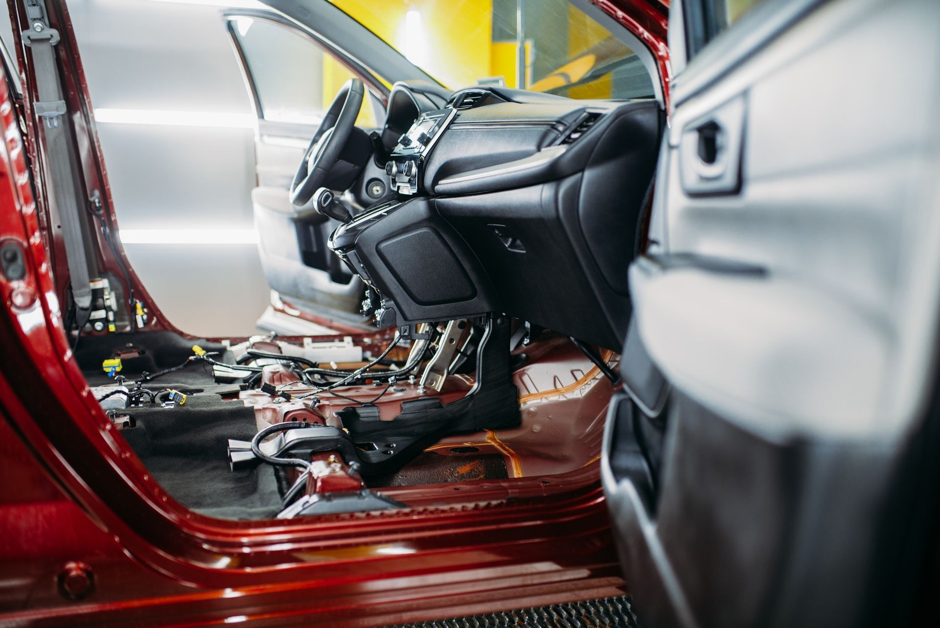 In einer Fabrik wird die Innenausstattung eines roten Autos gebaut.