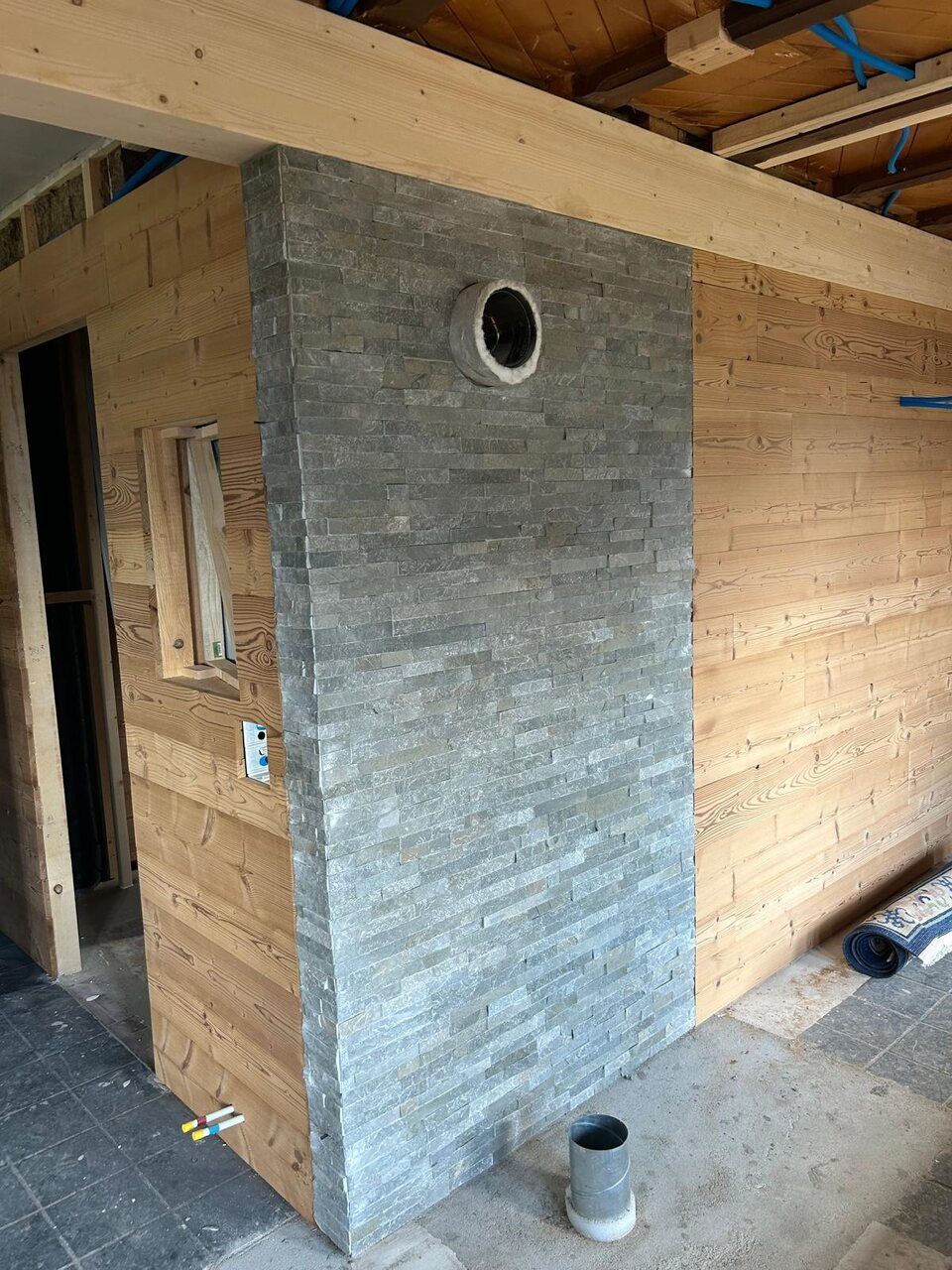 Une pièce avec un mur en bois et un mur en pierre.