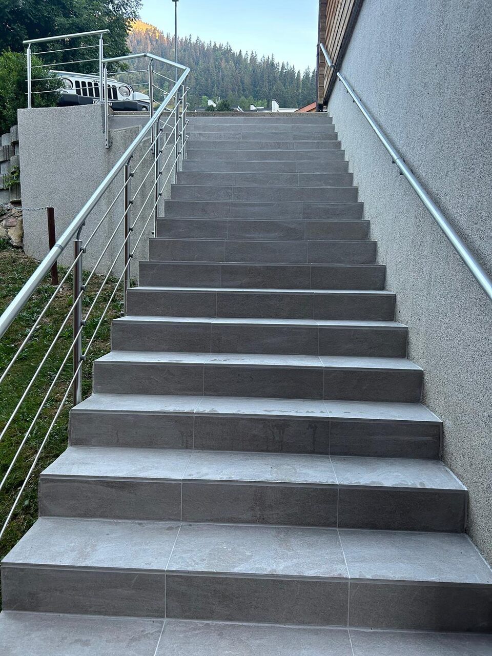 Un escalier menant à un bâtiment avec une rampe en métal