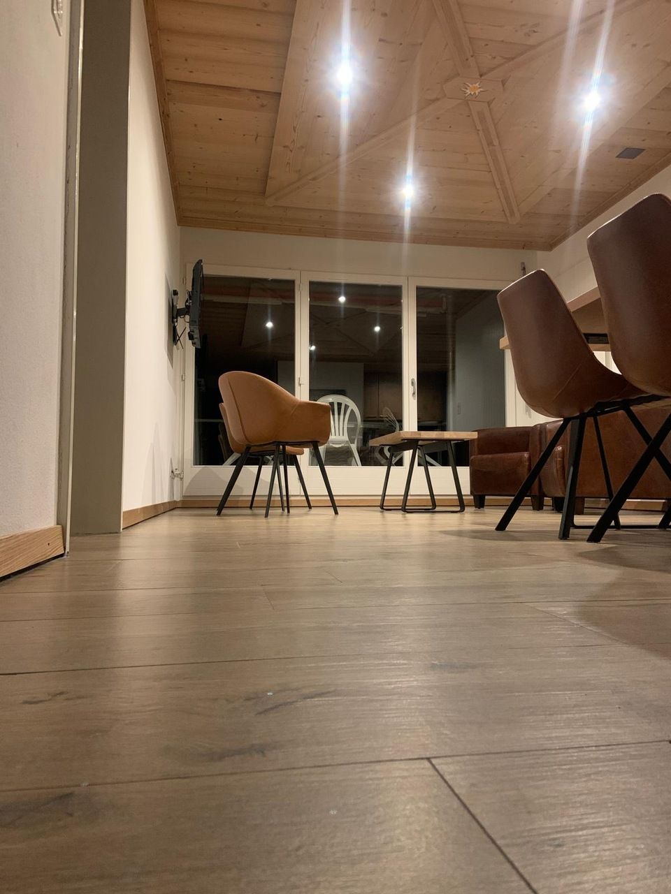 Un salon avec parquet et chaises