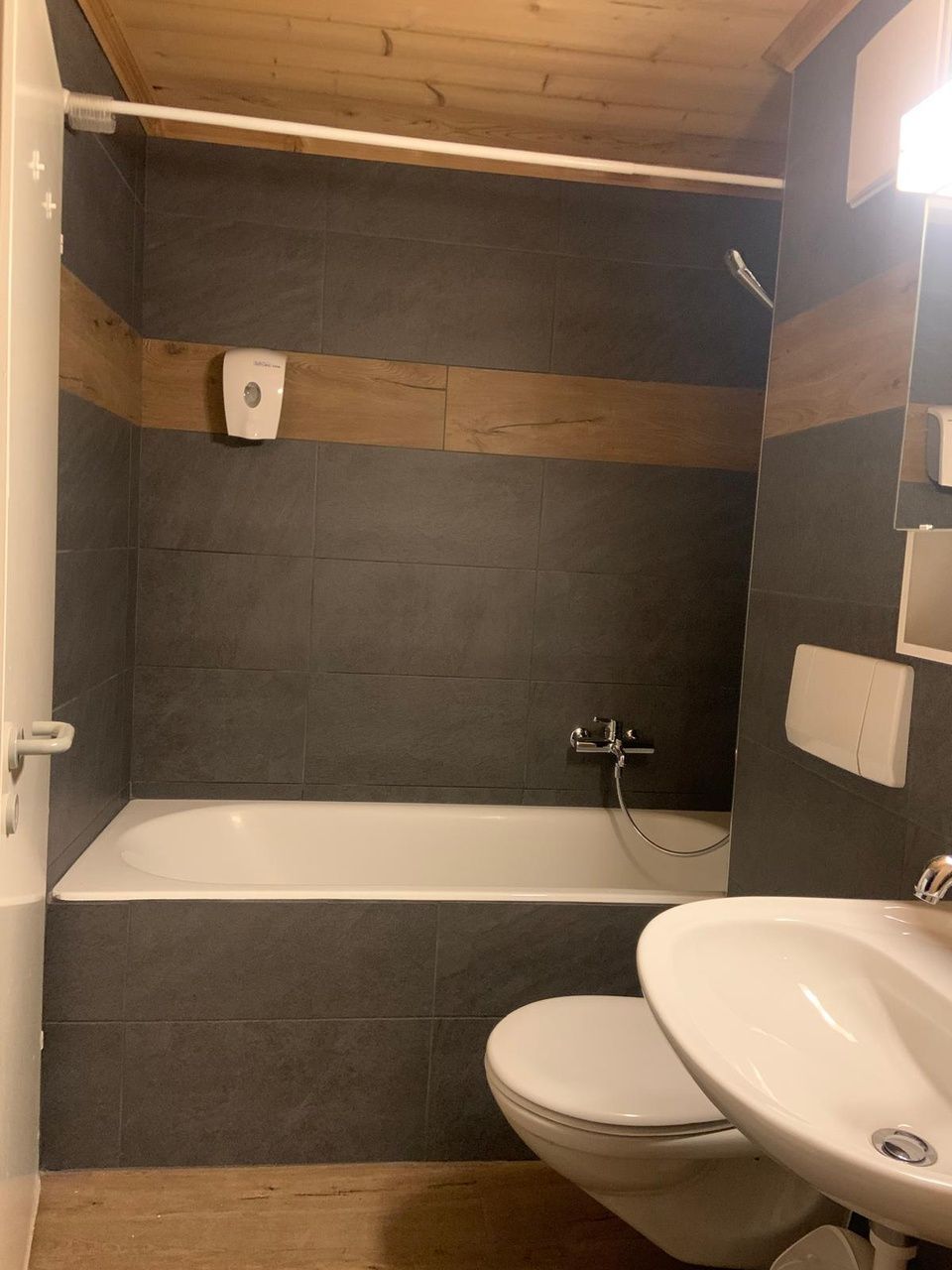 Une salle de bain avec lavabo, toilettes et baignoire