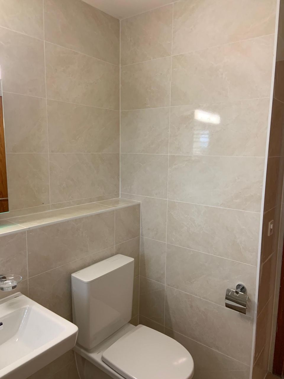 Une salle de bain avec WC , lavabo et miroir.