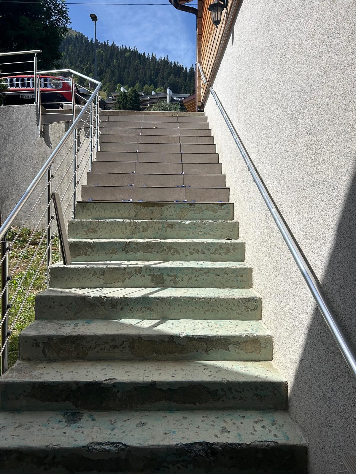 Un ensemble d'escaliers menant à un bâtiment avec une rampe en métal.
