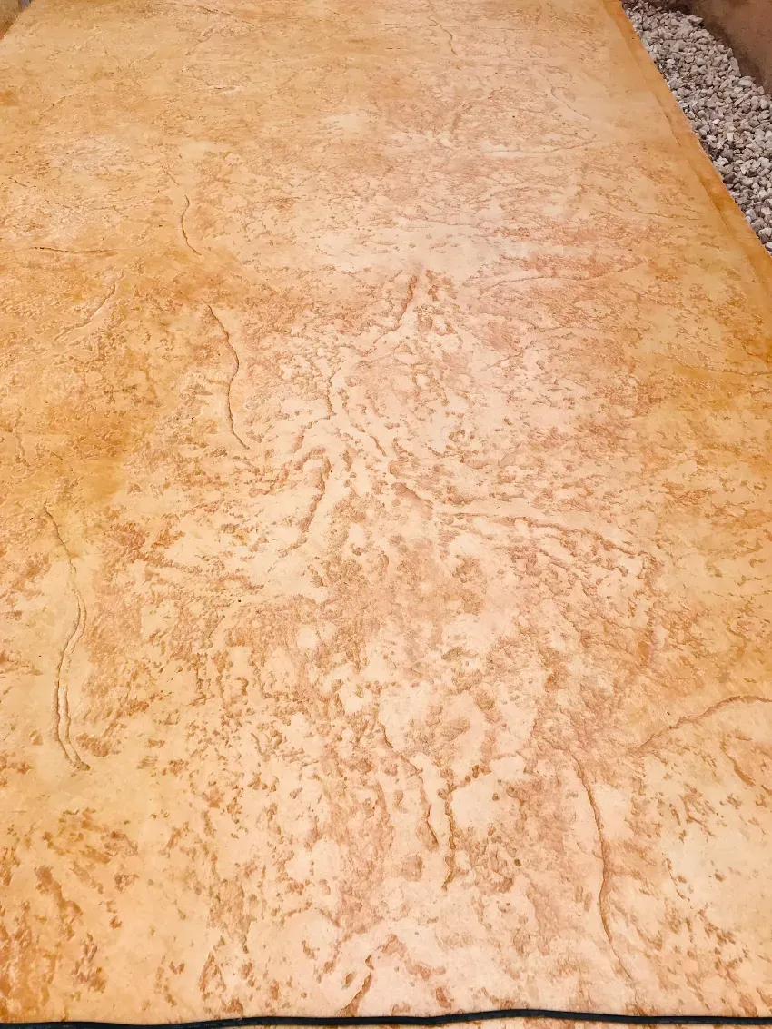 Superficie de color beige con textura y un borde oscuro estrecho en la parte inferior.