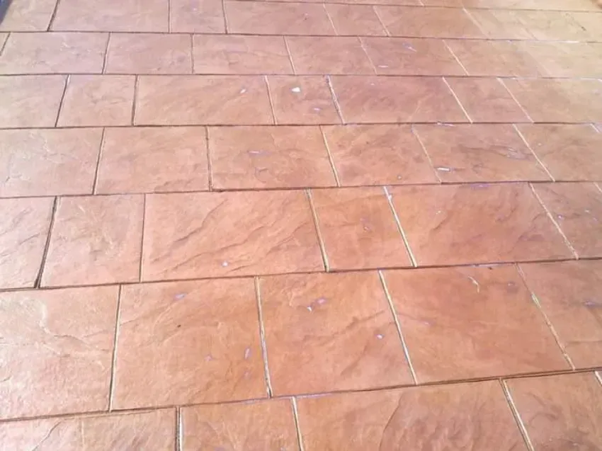 Pavimento de baldosas color terracota con losas de piedra rectangulares.