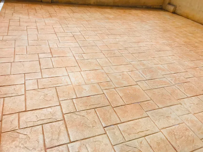 Suelo vacío de baldosas de terracota junto a una pared beige.
