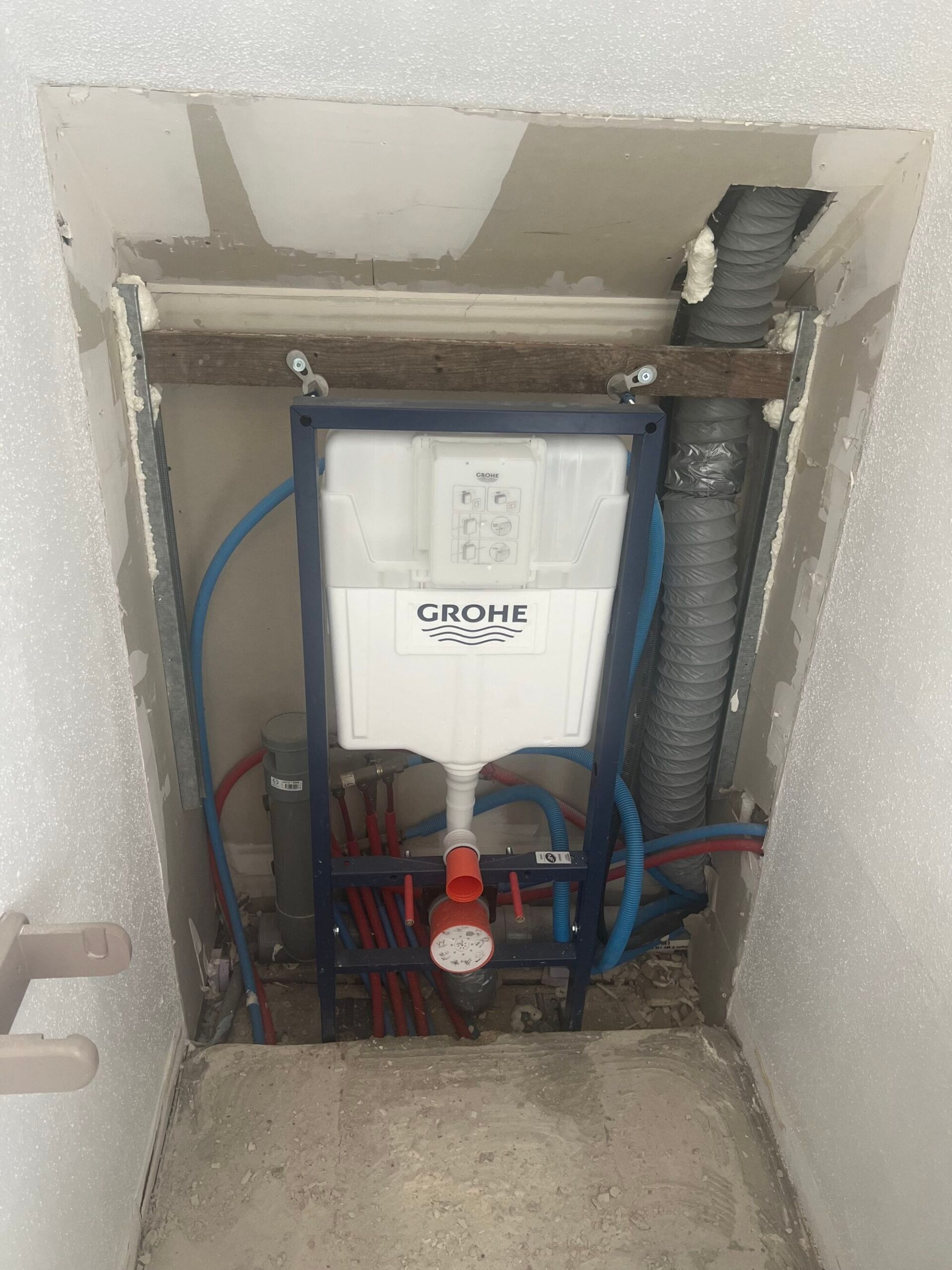 Installation d’un réservoir de chasse d’eau Grohe et de la plomberie apparente dans une cloison creuse