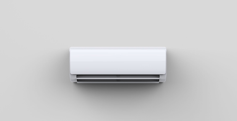 Climatiseur blanc fixé au mur sur un mur gris clair