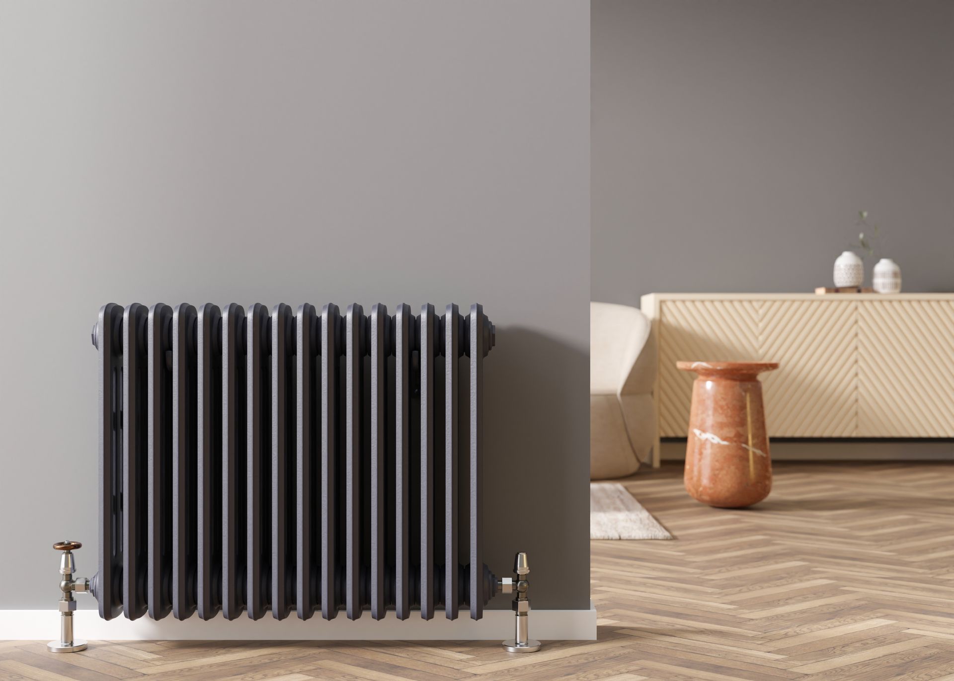 Radiateur noir contre un mur gris, à côté d’un canapé beige, avec une table d’appoint un parquet en bois.