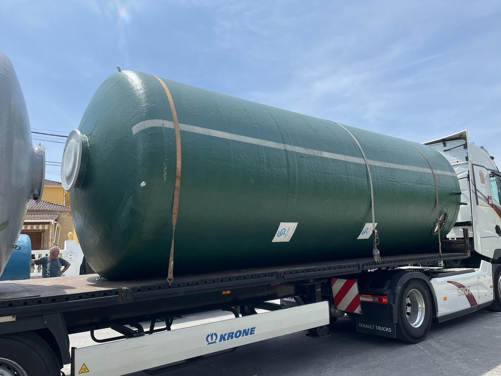 Un gran tanque verde está en la parte trasera de una grúa.