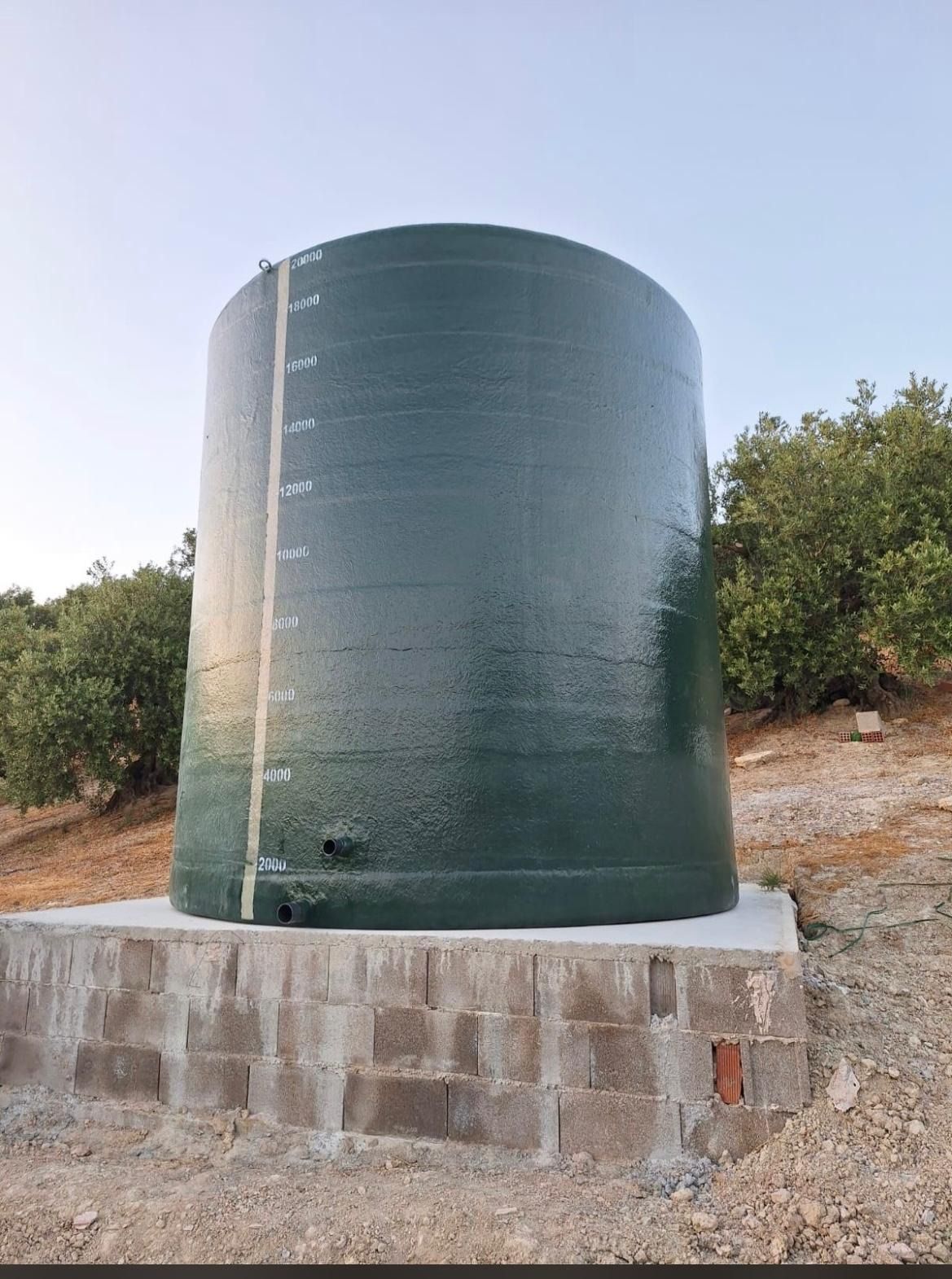 Un gran tanque de agua verde está situado encima de una plataforma de piedra.