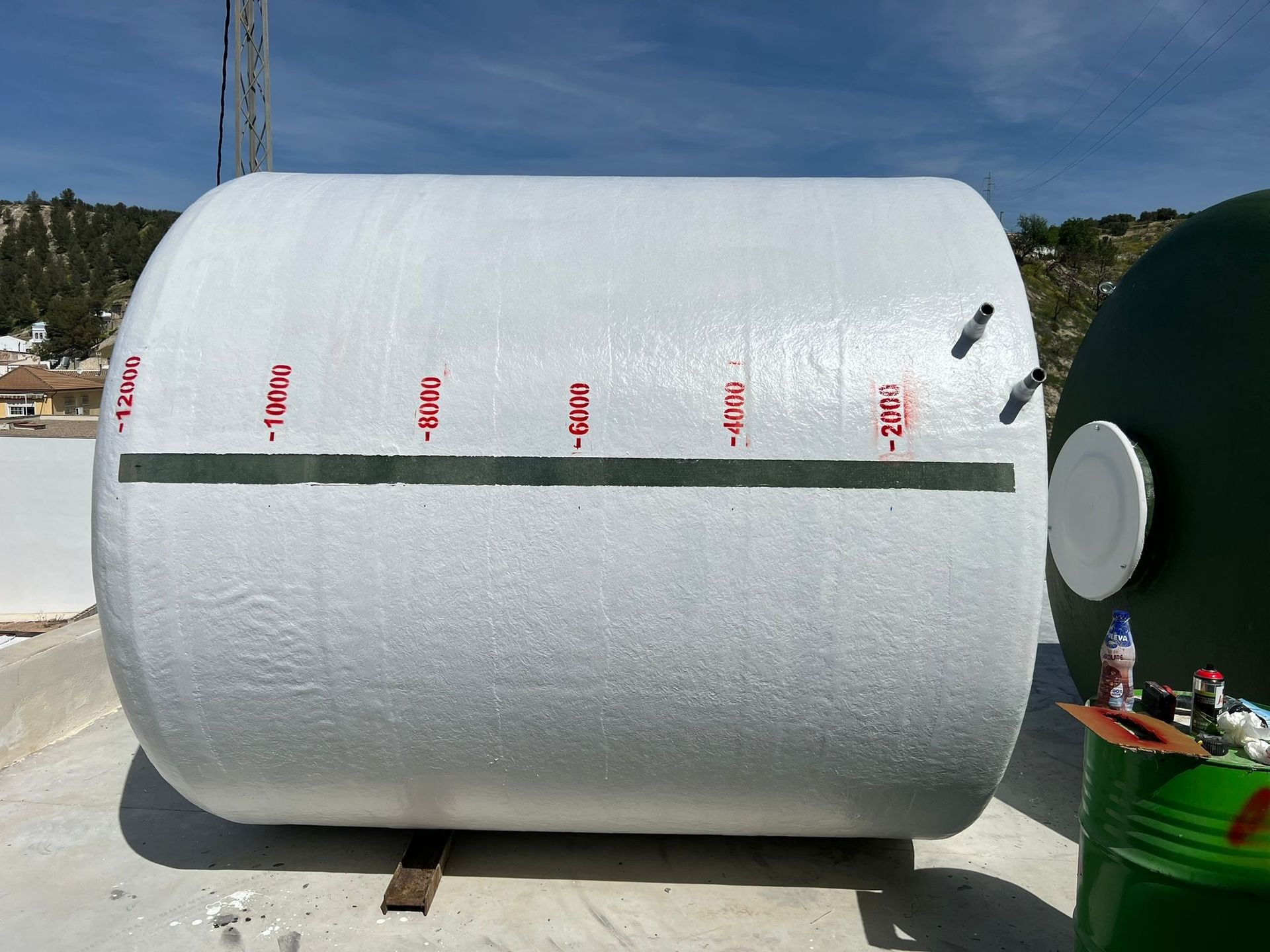 Un gran cilindro blanco reposa sobre una superficie de hormigón.