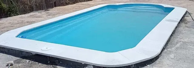 Una gran piscina rectangular llena de agua azul.