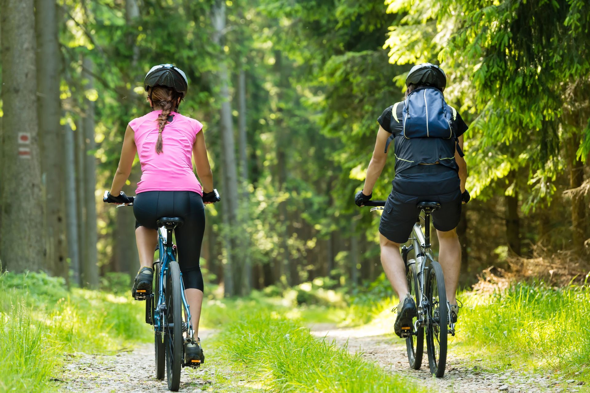 A light-filled dining room with rows of tables and gray upholstered chairs next to large windows overlooking a brick building.