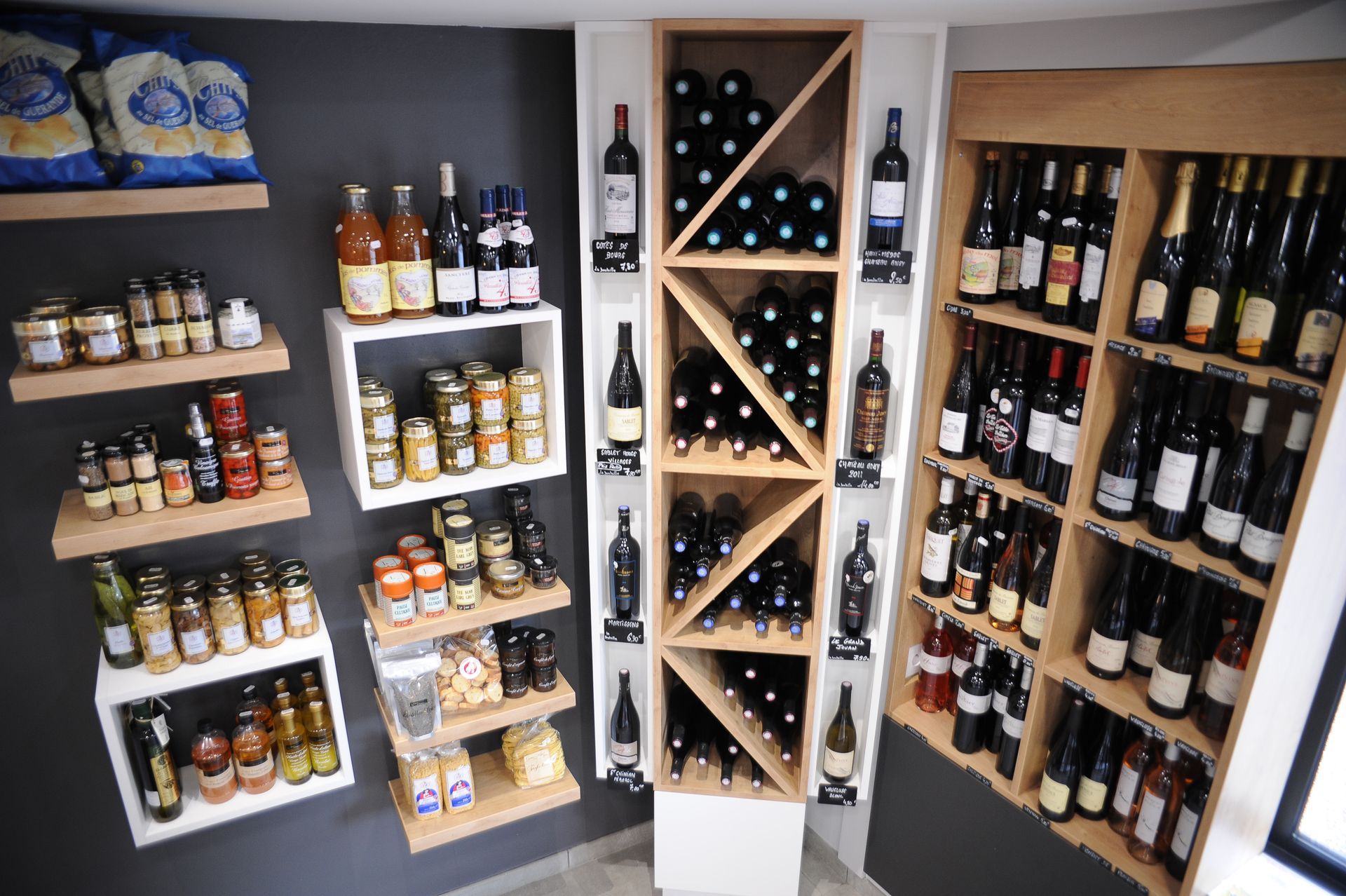 Rayonnages de vins et spiritueux avec bouteilles et canettes dans une petite vitrine de magasin.