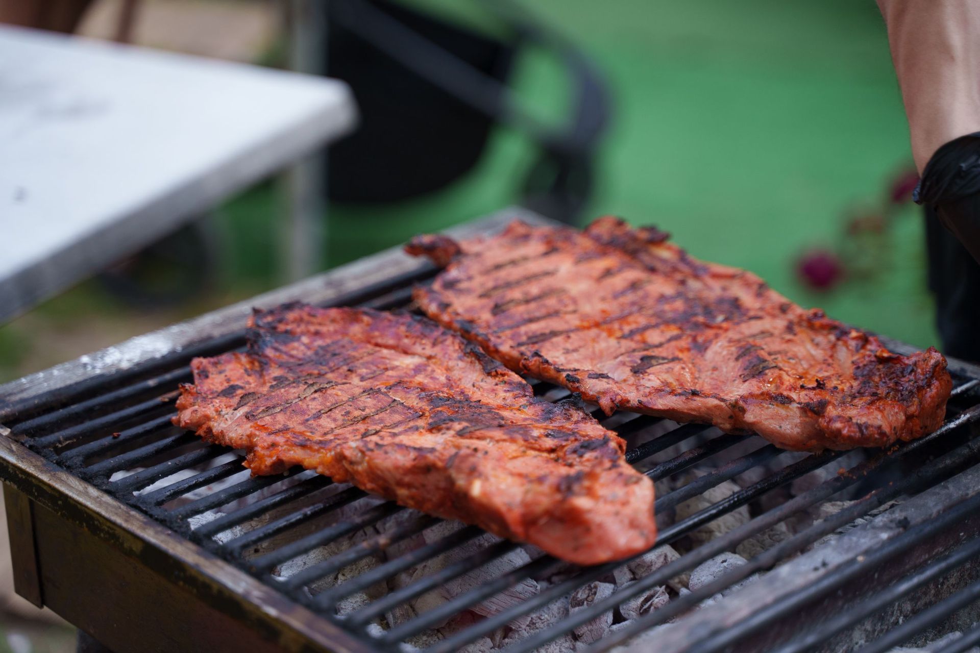 Deux steaks grillés grésillent sur un barbecue en plein air