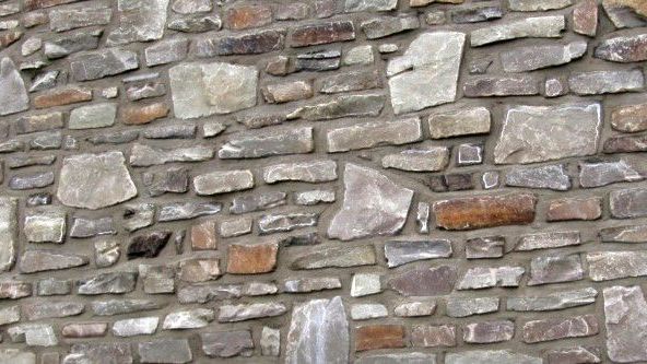 Eine Nahaufnahme einer Steinmauer mit vielen verschiedenen Steinarten