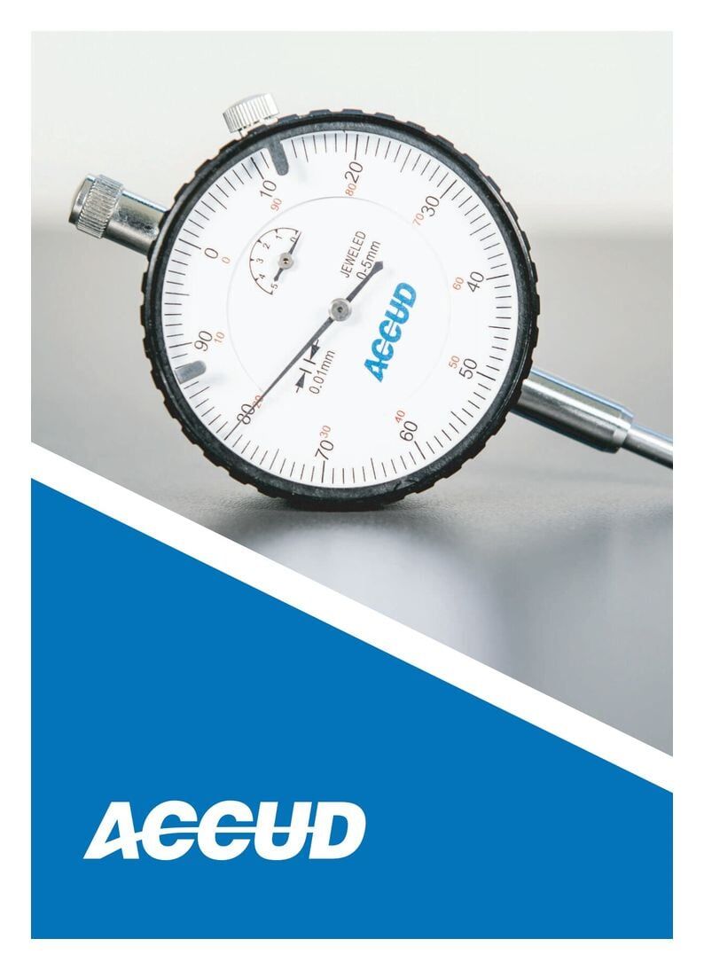 Imagem em close-up de um indicador de mostrador com face branca, aro preto e fundo azul inclinado.