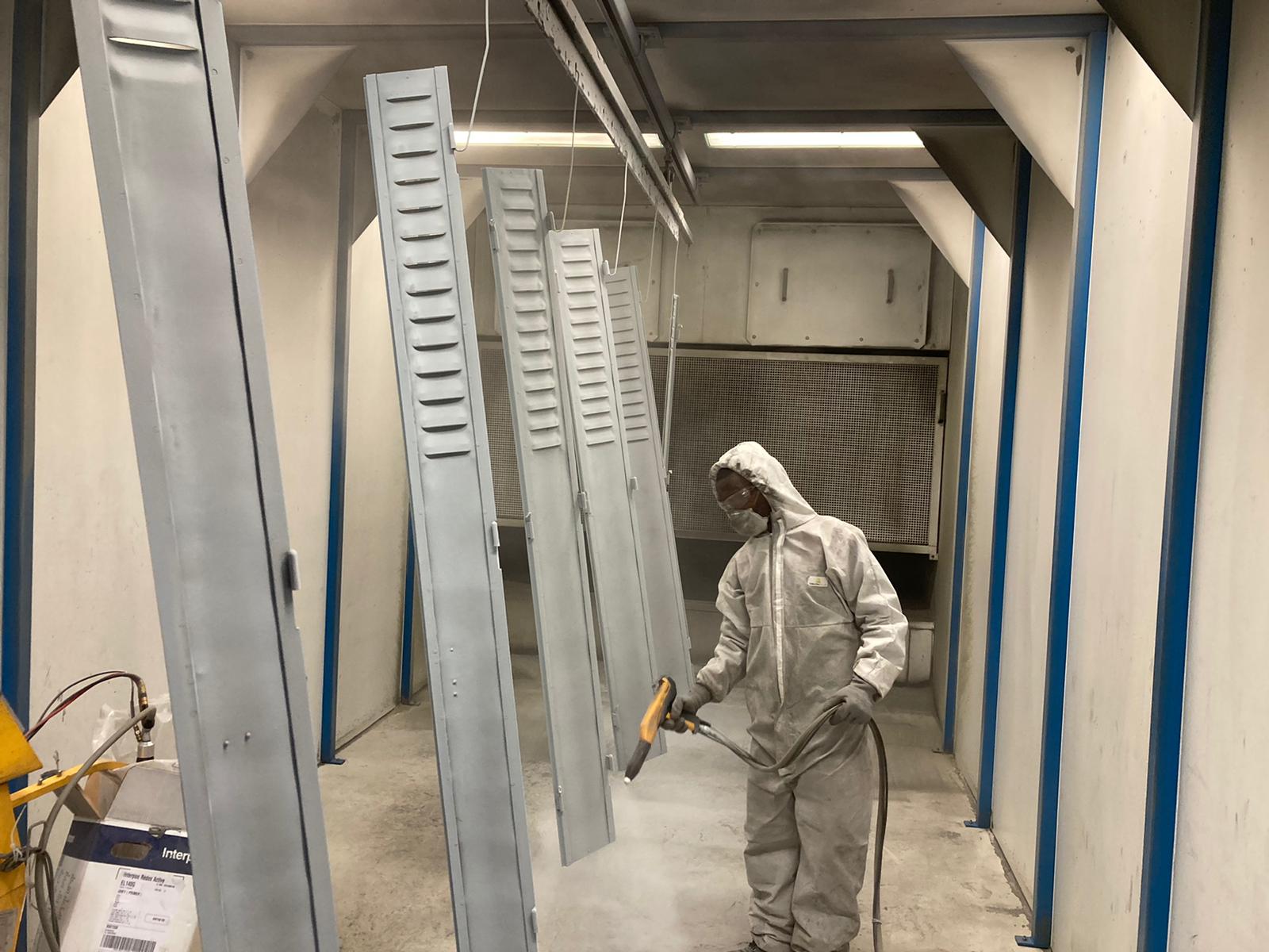 Photo d'une personne qui peind des volets de fenêtre et porte