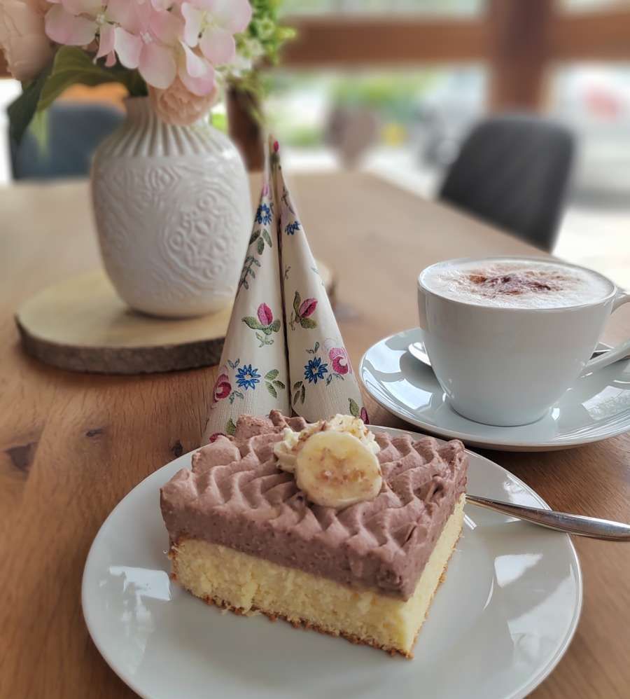 Schoko-Bananenkuchen mit einer Tasse Cappucchino