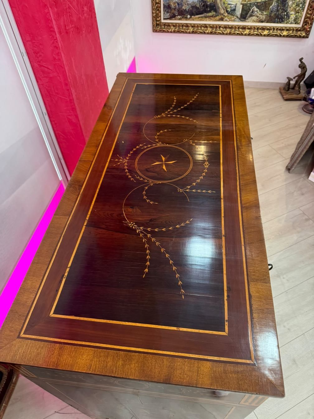 Mesa de madera oscura con incrustaciones doradas talladas, en una habitación, vista desde arriba.