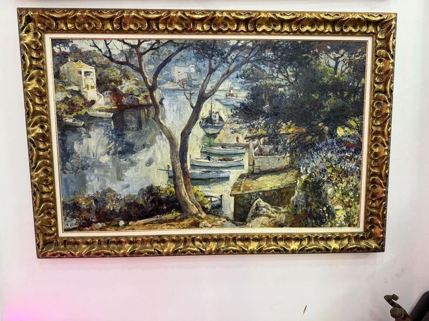 Cuadro enmarcado de un paisaje con un árbol y un lago, en tonos azules, verdes y beige