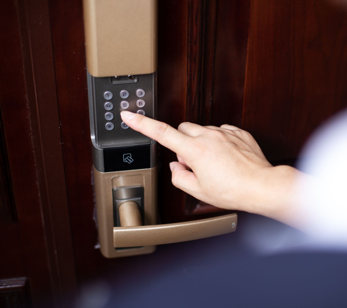 La main d'une personne saisissant un code sur une serrure de porte numérique