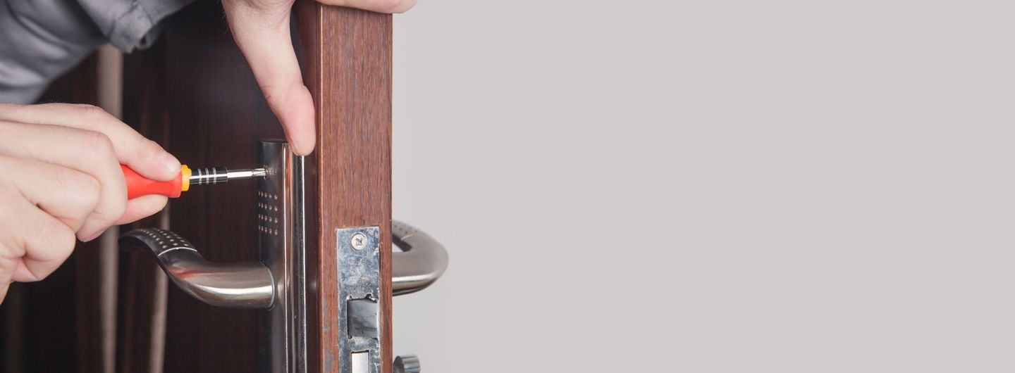 Un serrurier installe une poignée de porte d'entrée