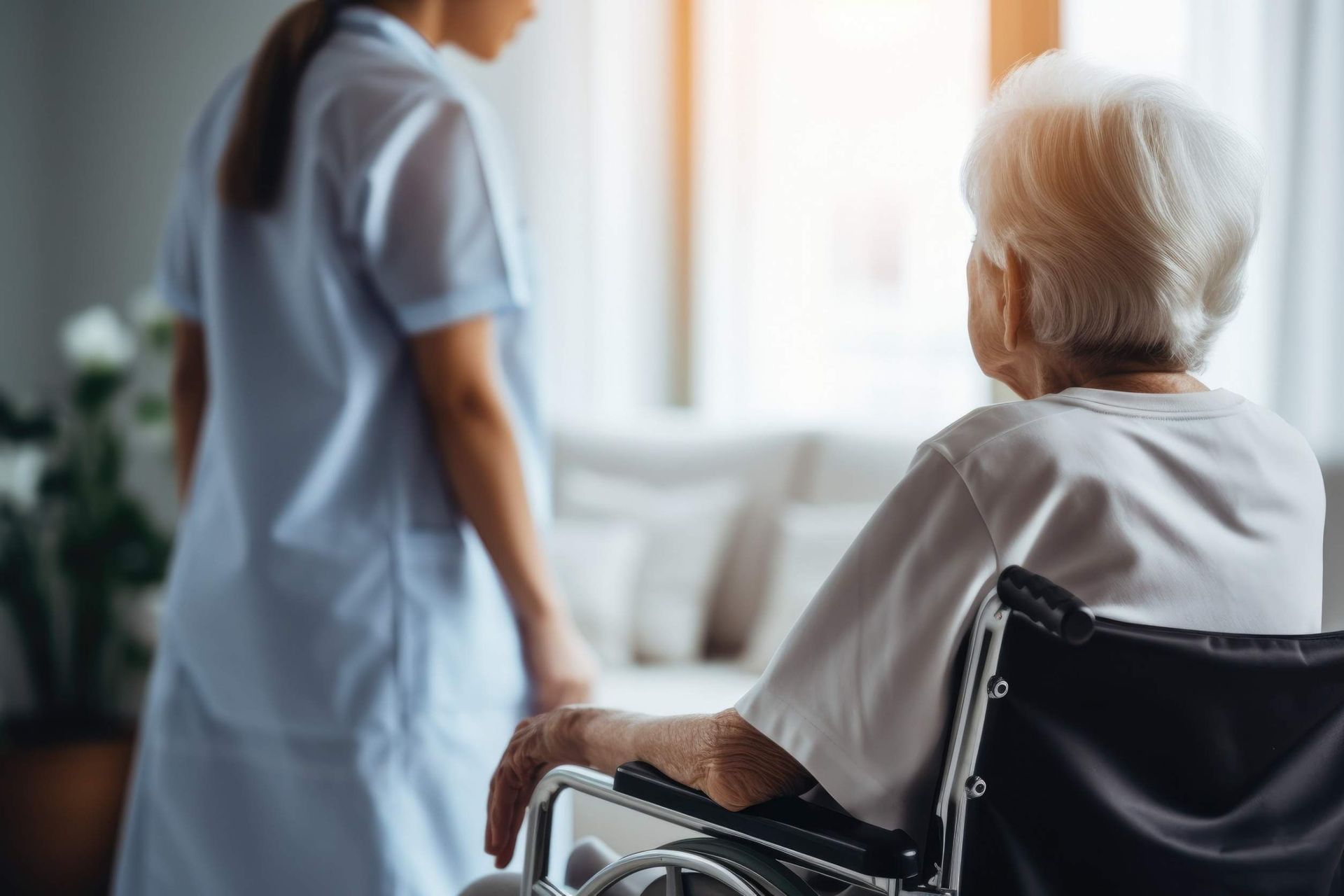 Una enfermera camina con una anciana en silla de ruedas.