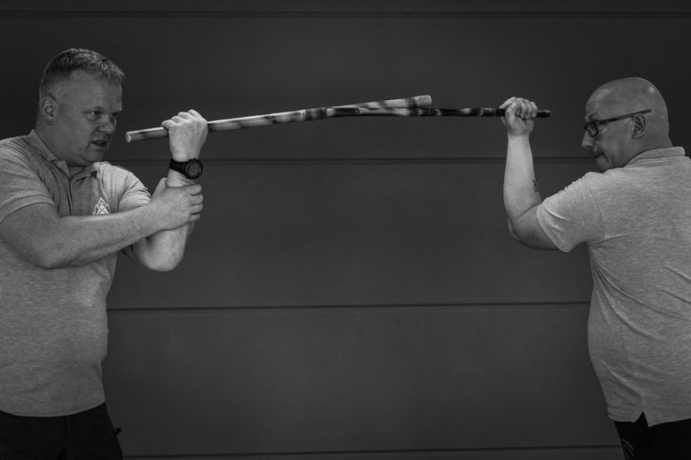 Zwei Kampfsporttrainer demonstrieren den Stockkampf.