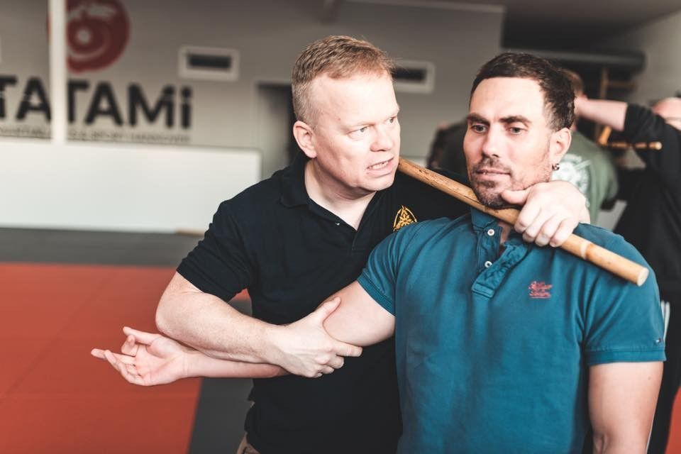 Zwei Kampftrainer und ein Schüler beim Üben auf der Matte