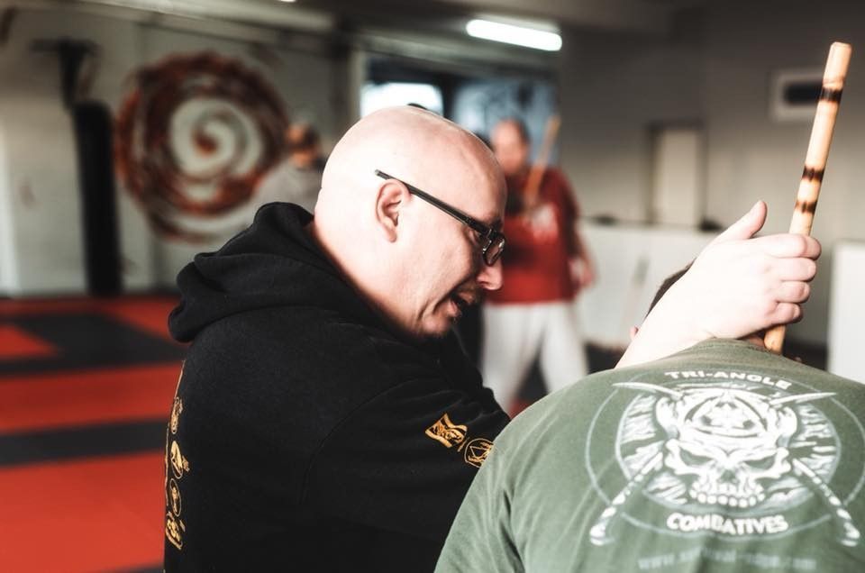 Zwei Kampftrainer und ein Schüler beim Üben auf der Matte