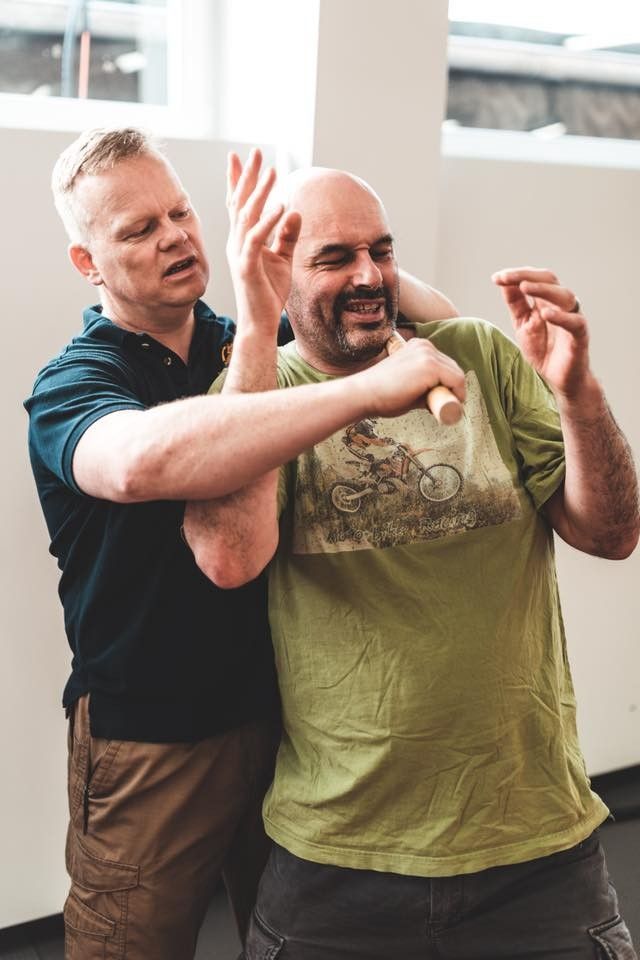 Zwei Kampftrainer und ein Schüler beim Üben auf der Matte