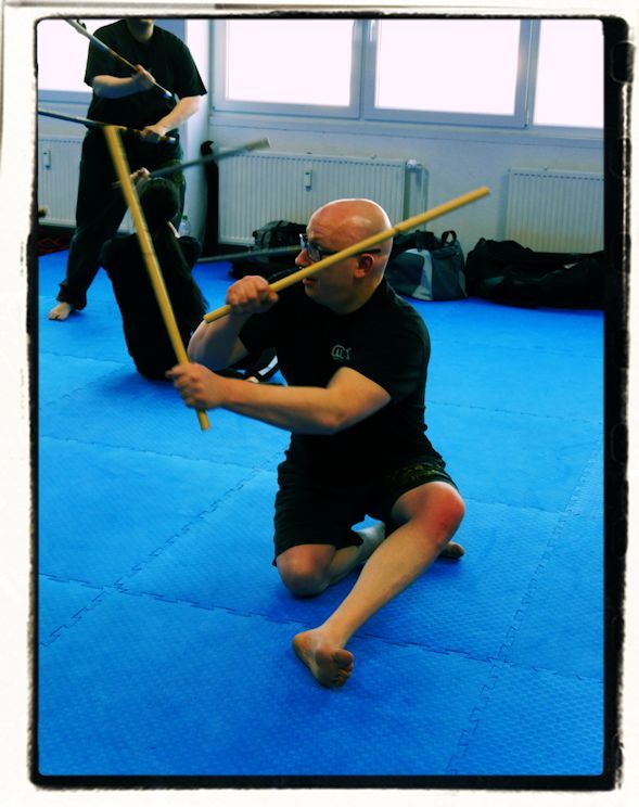 Zwei Kampftrainer und ein Schüler beim Üben auf der Matte