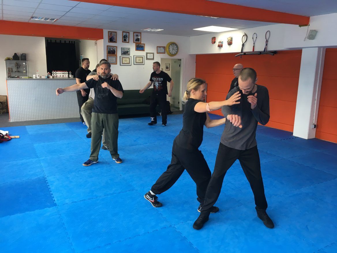Zwei Kampftrainer und ein Schüler beim Üben auf der Matte