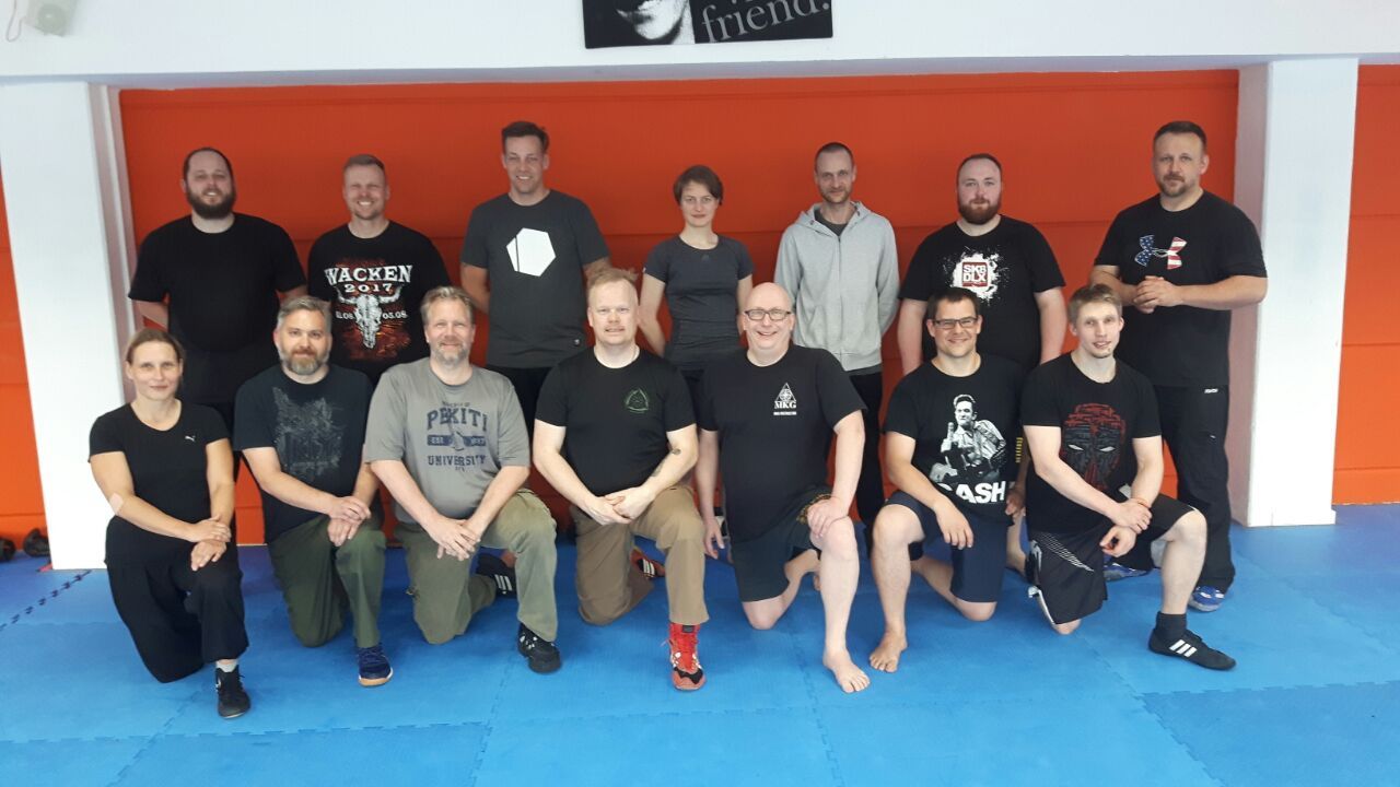 Zwei Kampftrainer und ein Schüler beim Üben auf der Matte