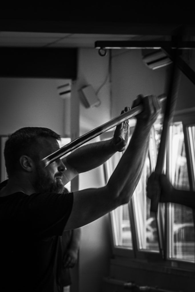 Zwei Kampftrainer und ein Schüler beim Üben auf der Matte