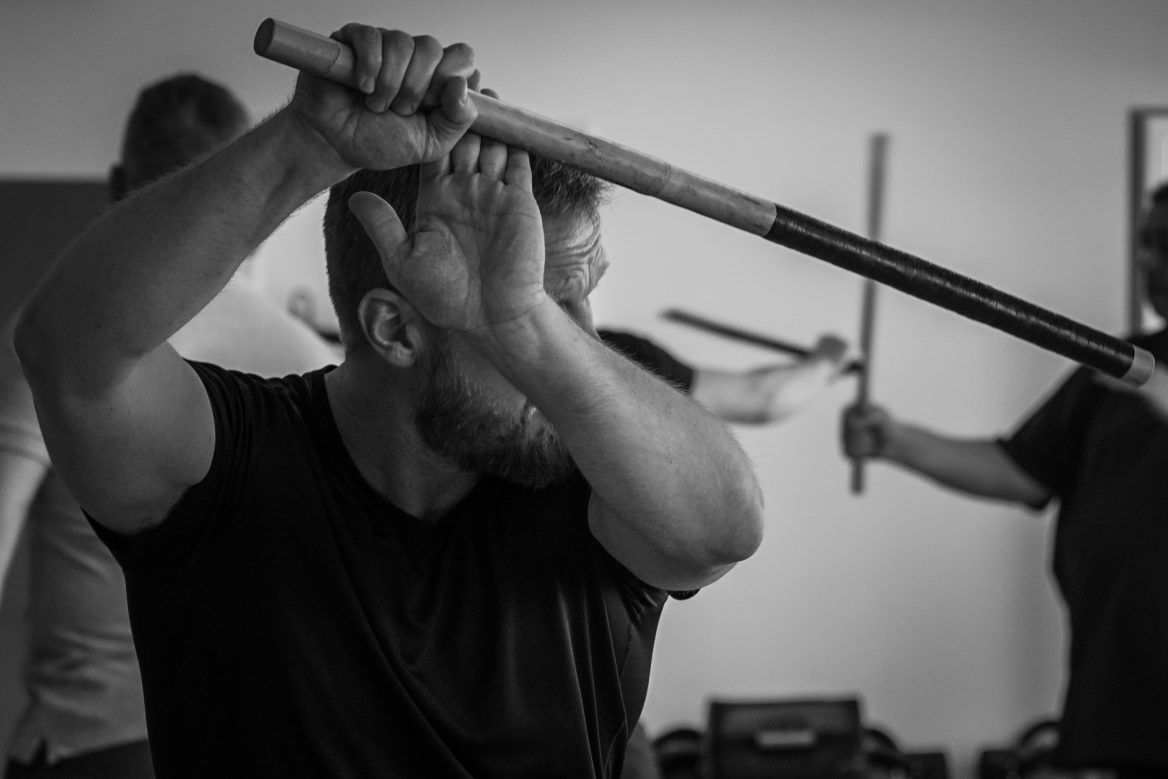 Zwei Kampftrainer und ein Schüler beim Üben auf der Matte