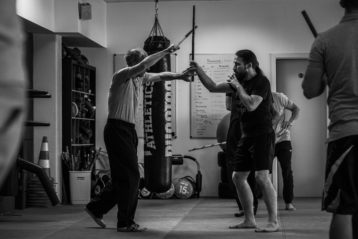 Zwei Kampftrainer und ein Schüler beim Üben auf der Matte