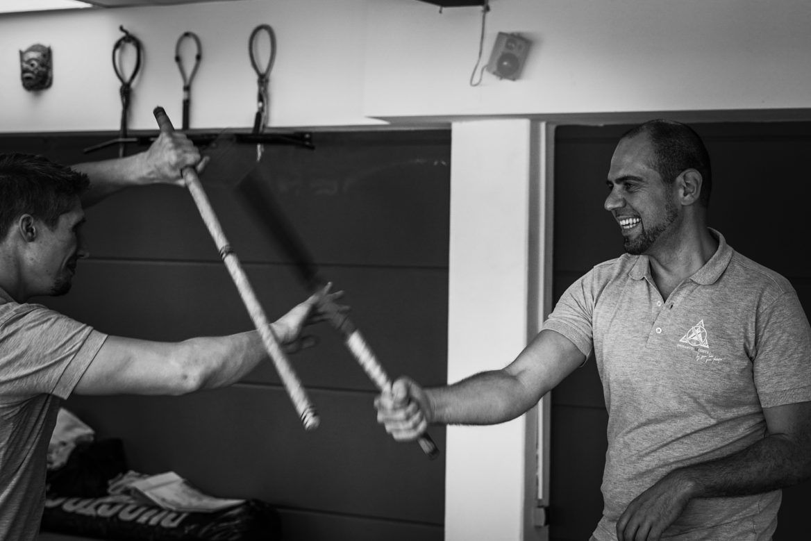 Zwei Kampftrainer und ein Schüler beim Üben auf der Matte