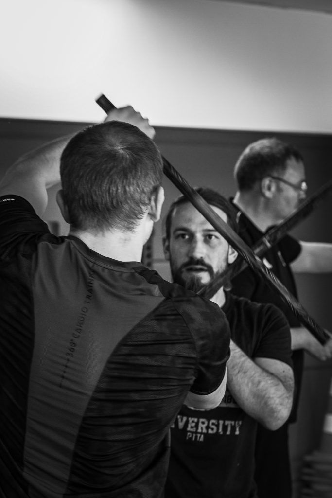 Zwei Kampftrainer und ein Schüler beim Üben auf der Matte