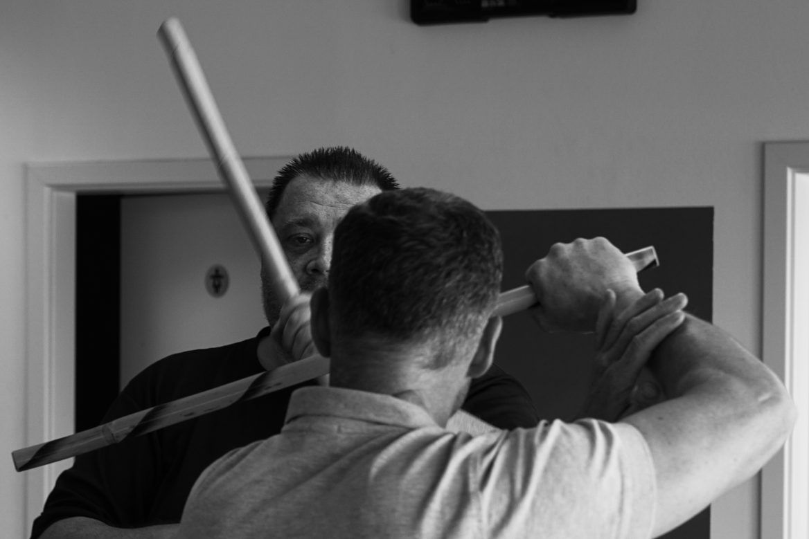 Zwei Kampftrainer und ein Schüler beim Üben auf der Matte