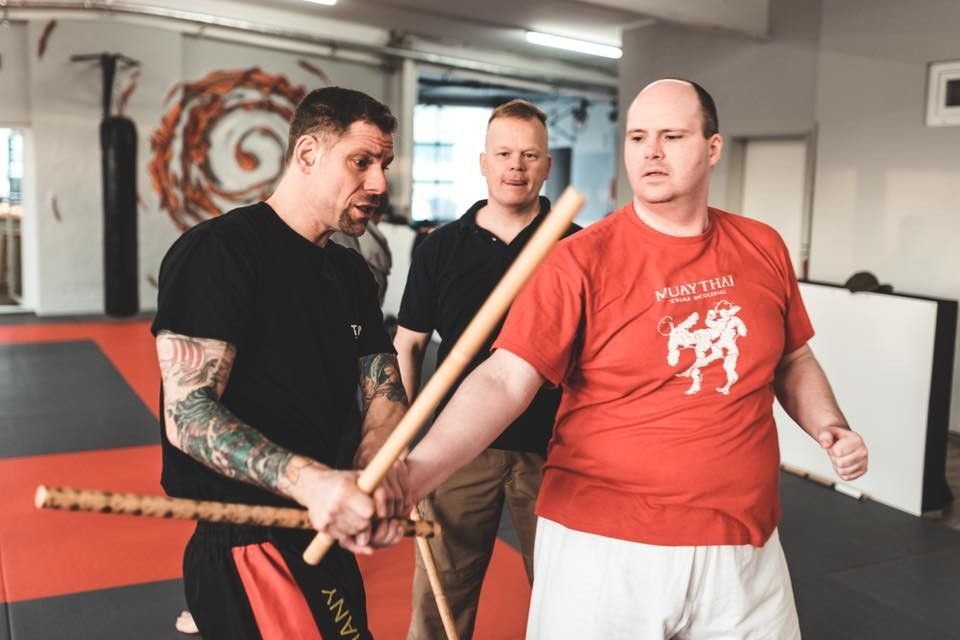 Zwei Kampftrainer und ein Schüler beim Üben auf der Matte